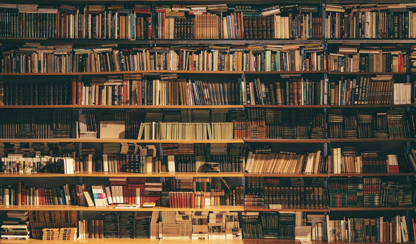 Високі дерев’яні полиці з книгами